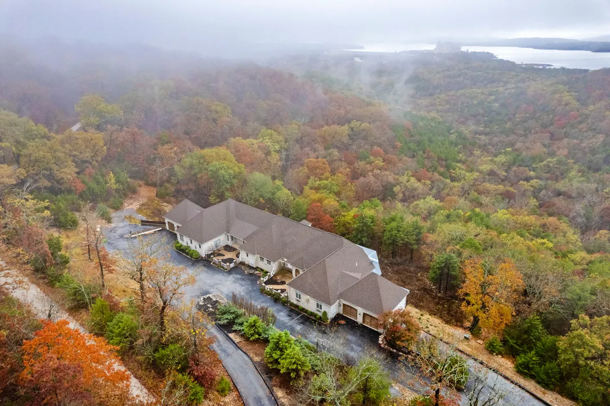 A broad exterior view of the property surrounded by vibrant autumn foliage and a winding driveway. The spacious house exudes tranquility and provides a sense of arrival and retreat, perfect for family gatherings and launching day trips to nearby attractions.