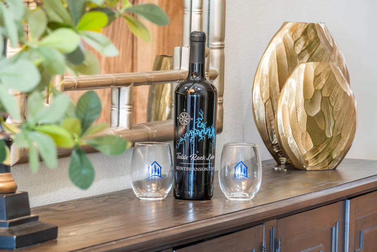 A sophisticated vignette showing a wine bottle and glasses set atop a decorative surface, evoking an atmosphere of elegance and relaxation. The setting invites guests to share a drink, socialize, and create memorable moments—echoing themes of indulgence and upscale amenities.