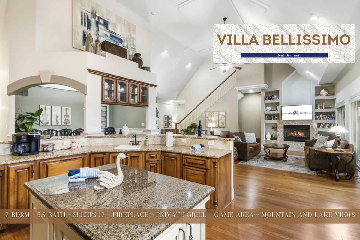 This image showcases an open-concept layout with a seamless flow between the kitchen and living area. It features a granite countertop, stainless steel appliances, a fireplace, and large windows that bring in natural light and offer mountain and lake views. The space is spacious, inviting, and designed for gatherings, with ample seating and a warm atmosphere.